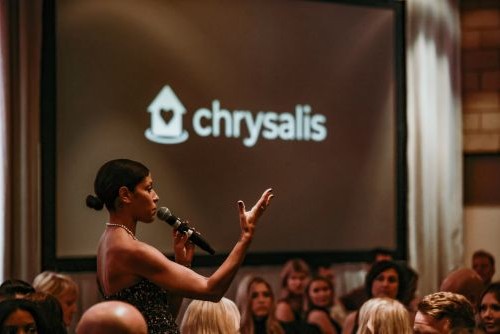 Fundraising guests raising bid paddles during a nonprofit auction event.